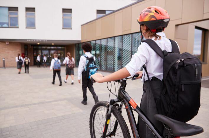 Students walking onto the school campus with backpacks and bikes to start the school day | image accompanies a Truth Tree blog post on the best ways to adapt a school marketing strategy with South Korean families in mind | Truth Tree knows school marketing