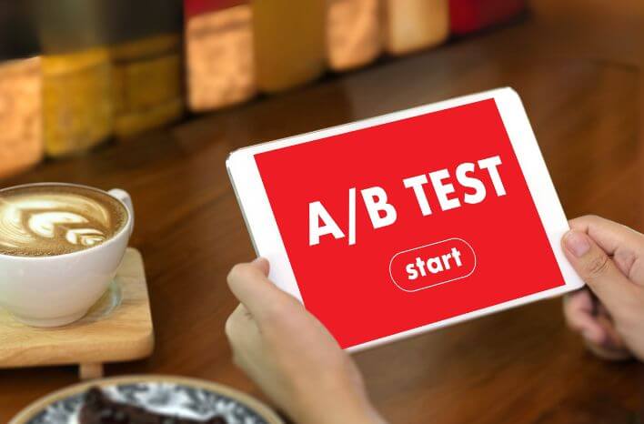 person holding a tablet that reads "A/B Test" in white letters on a red background with "start" sitting just beneath it | image accompanies a blog post published by Truth Tree | Truth Tree provides digital marketing strategies and solutions for schools